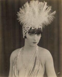 louise brooks in a show girl's costume with big feather headdress