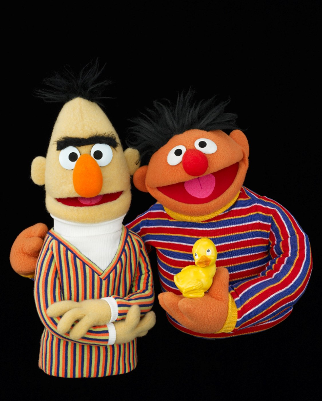 The puppets Bert and Ernie, with Ernie on the right of the image, holding a rubber duckie and with one arm around Bert