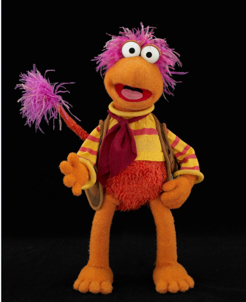 The Fraggle Gobo with purple hair and a striped shirt in full body puppet pose