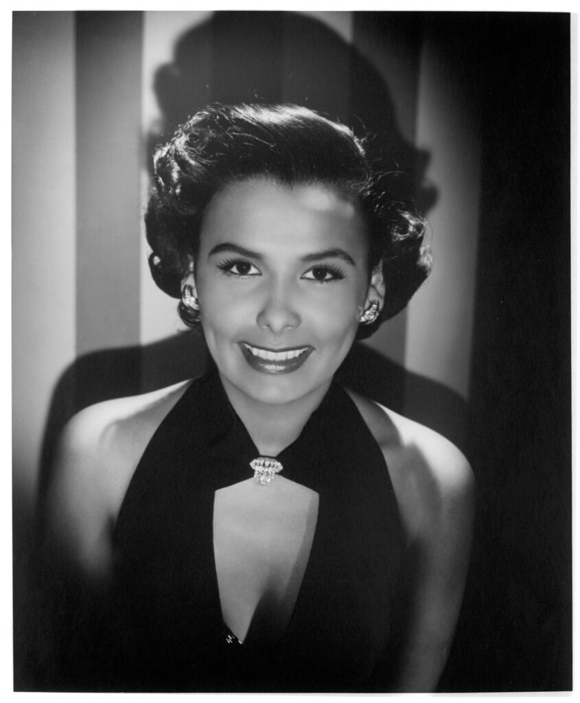 Medium close-up of the star Lena Horne in black and white, looking at camera