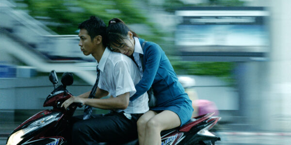A man and a woman on a motorcycle in motion