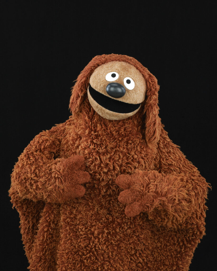 The puppet Rowlf, with brown fur, smiling and looking at camera