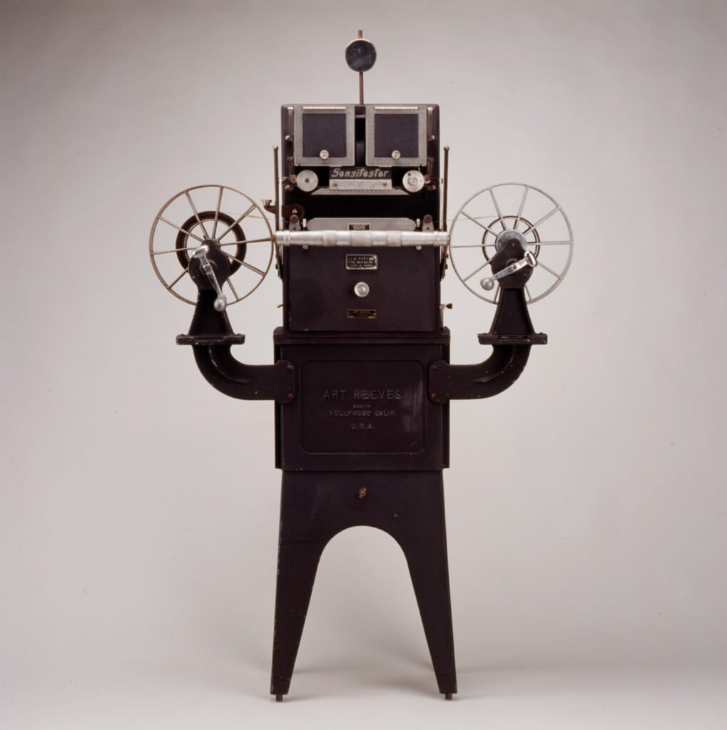 A sensitester motion picture tester, a piece of equipment that looks like a robot holding up two arms that are film reels