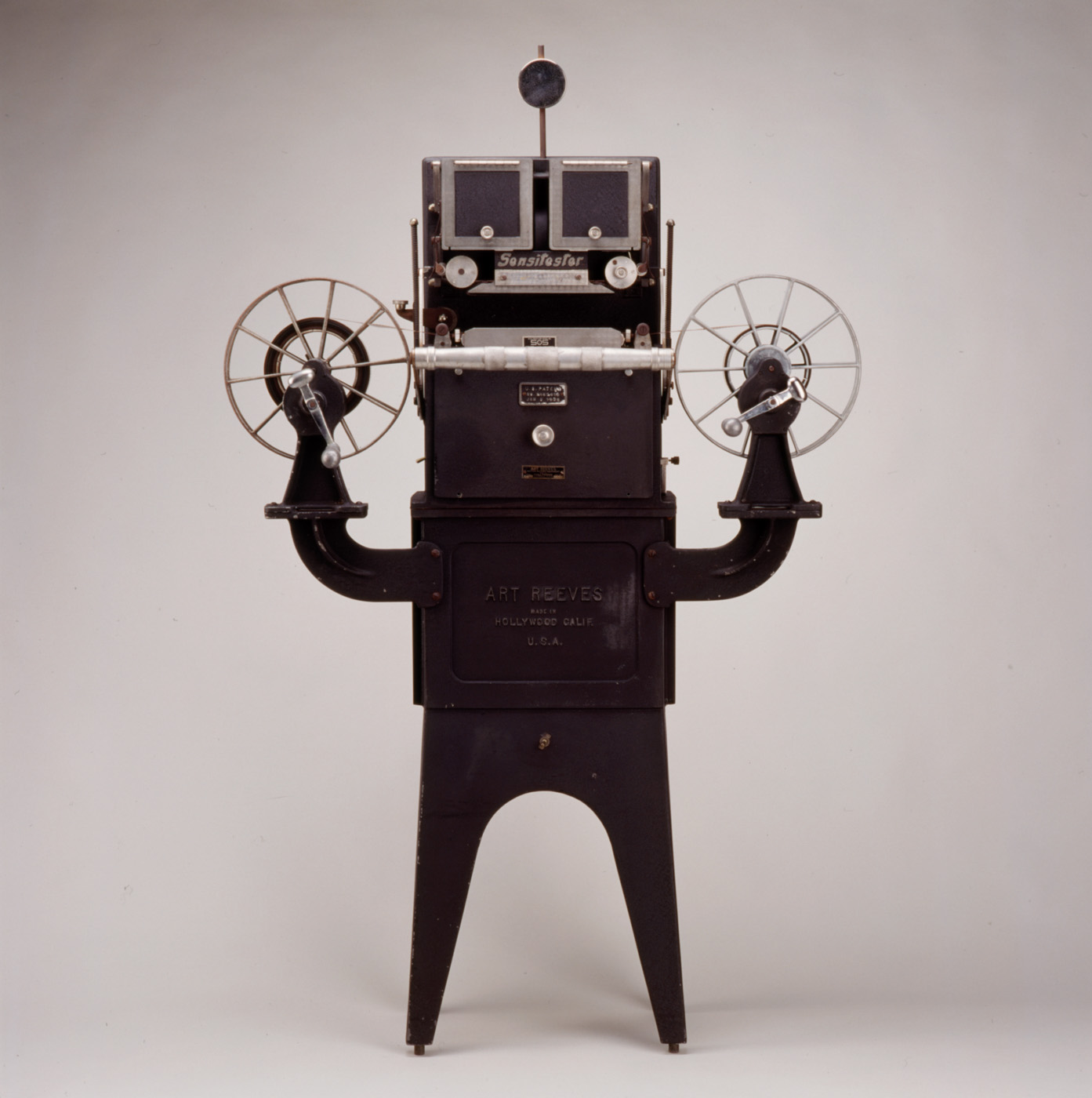 A sensitester motion picture tester, a piece of equipment that looks like a robot holding up two arms that are film reels