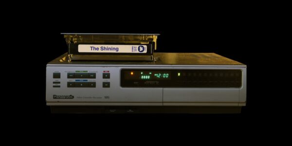 A VHS tape of The Shining being inserted into an old VHS machine.