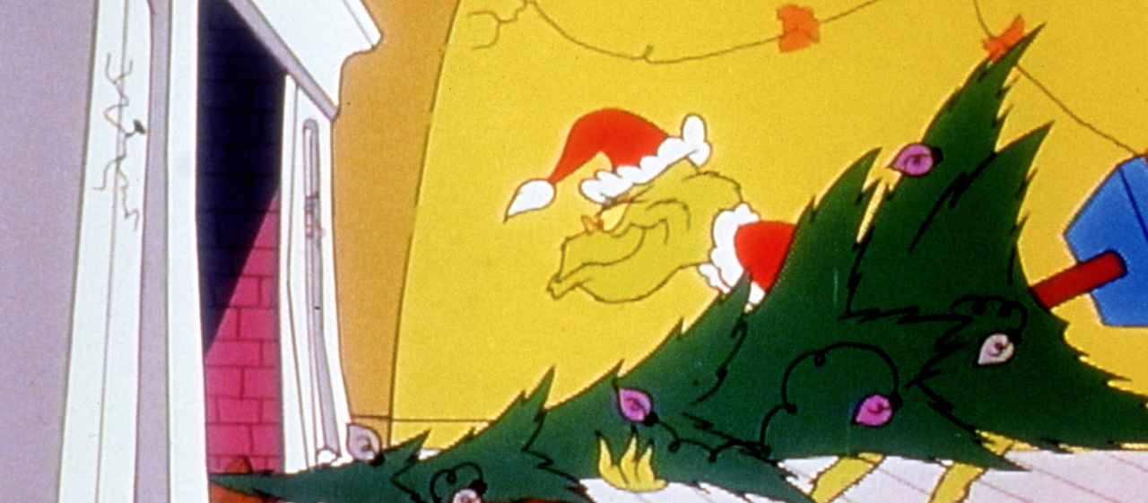 The animated character the Grinch, in a Santa Hat, tries to stuff a tree up a chimney.