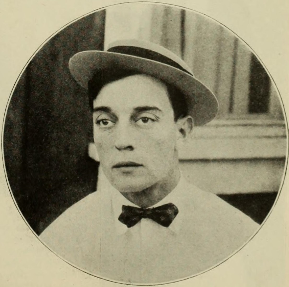 a man in a pork pie hat, white shirt and bow tie