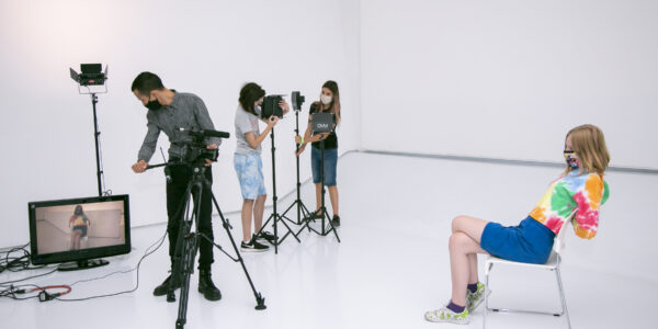 Students and film equipment in the digital learning suite at MoMI; the camera is on the left, a woman in a chair being filmed on the right