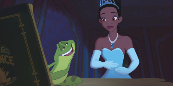 cartoon still of a green frog holding a book and talking to a Black girl dressed as a princess