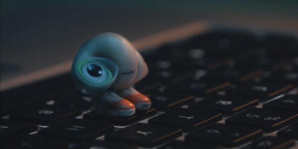 A tiny shell with shoes perches on a keyboard
