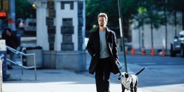A man walks a dog on a New York street