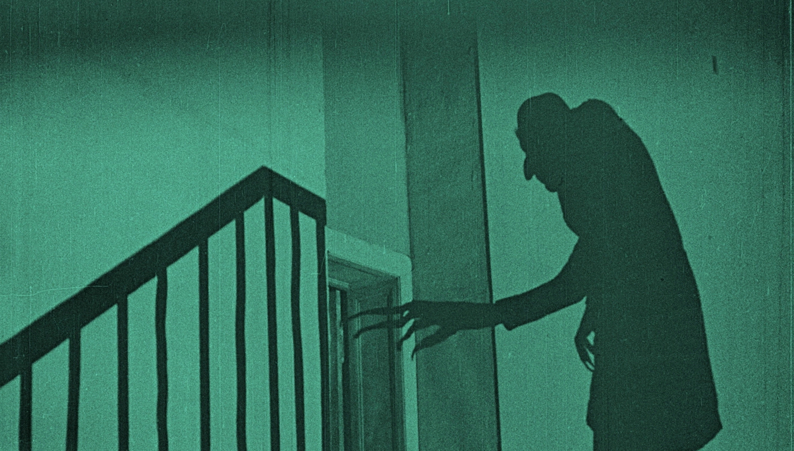 A vampire shadow reaches for a door at the top of a staircase.