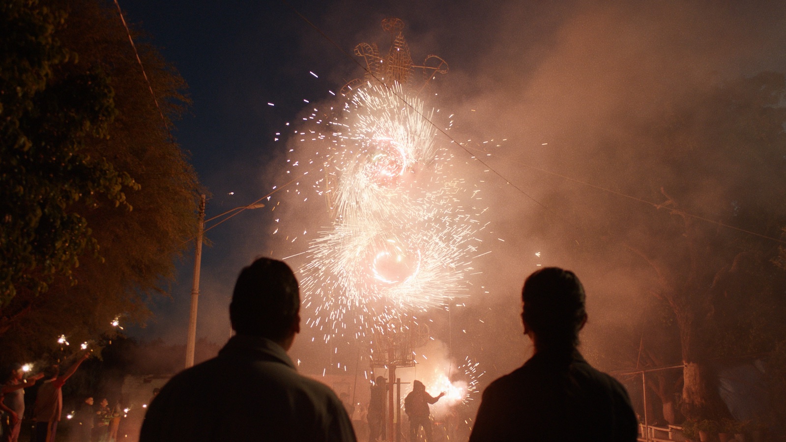 Two people silhouetted from behind looking at fireworks