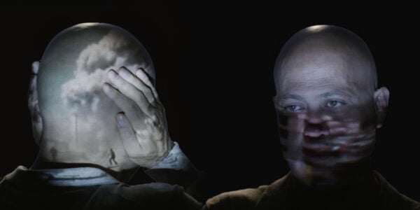 An image of a man with his hands over his ears with images of clouds reflected on his head facing an identical man facing him