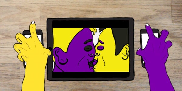 An animated image on a desktop screen, of two people, one purple and one yellow, kissing. Two hands, one yellow and one purple, extend on either side of the screen.