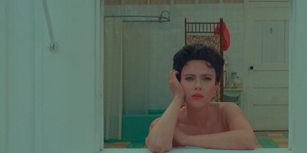 A brunette woman with short hair looks out a window