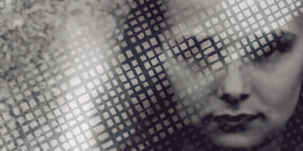 A black and white photo of a girl's face looking at camera, covered partly by a white grid of rectangles