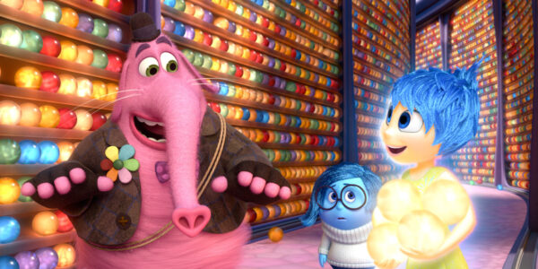 still from an animated film that shows a pink elephant-like creature next to two other cartoonish girl characters