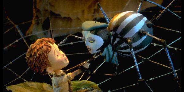 A stop motion animated image of a boy and a spider wearing a hat in a spider web