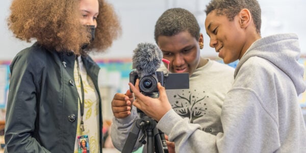 A MoMI educator helps two students work a camera in the Museum's after-school program